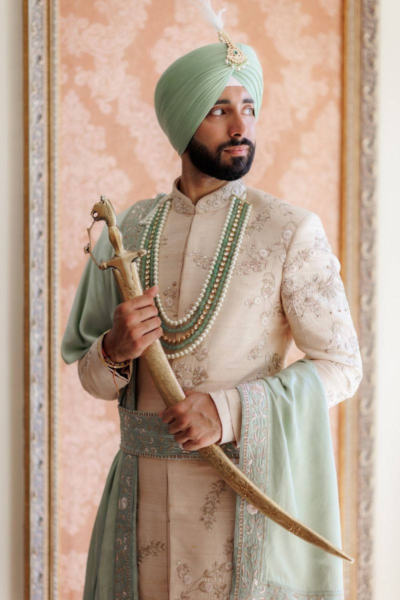 Close-up shot of the hand of the Indian groom wearing embraided sherwani  and a watch on the hand Stock Photo by wirestock
